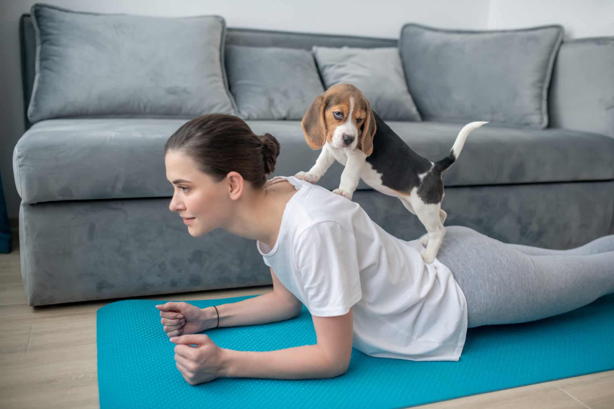 A girl exercising with her puppy.